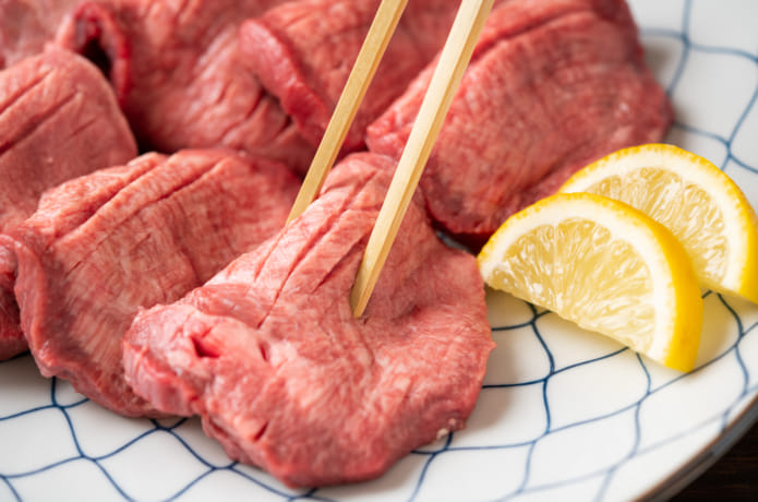 生の牛タンを箸で掴んでいる様子
