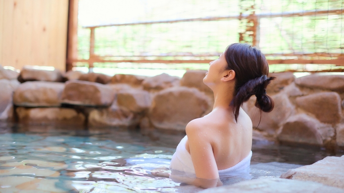 秋保風雅の岩風呂に女性が入浴している様子