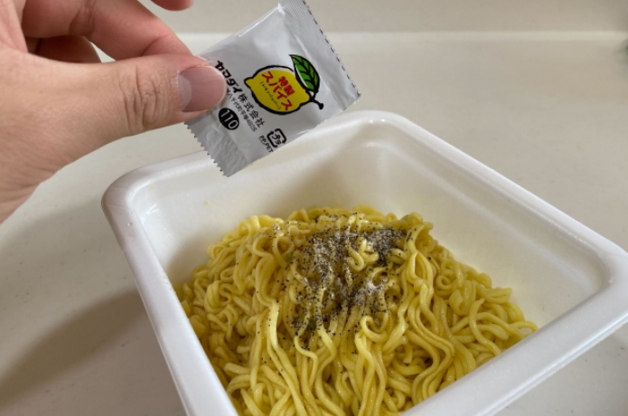 仙台牛タン風味塩焼きそばに付属のスパイスをかけているようす